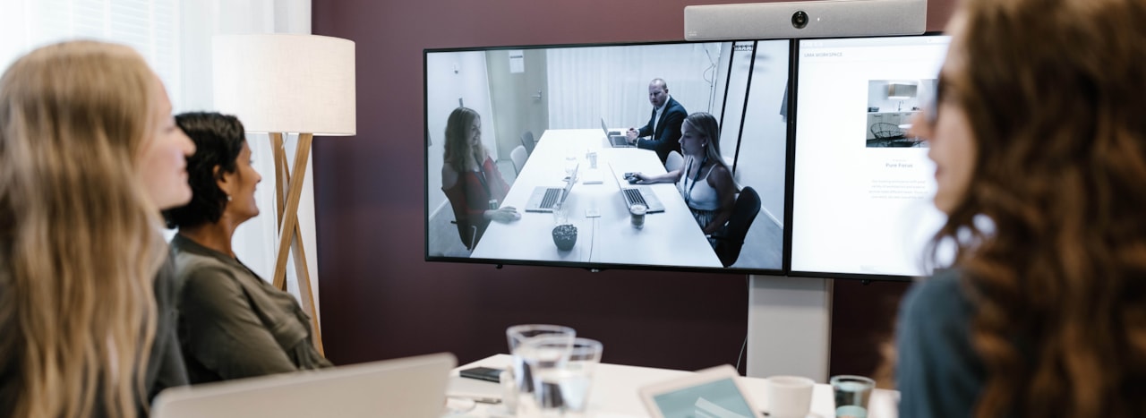 Personer i ett mötesrum tittar på en skärm.