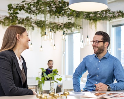 Två personer samtalar vid ett bord.