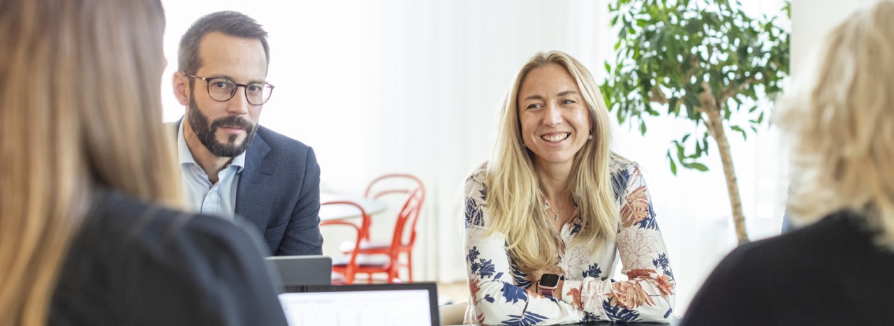 Människor kring ett bord med datorer.