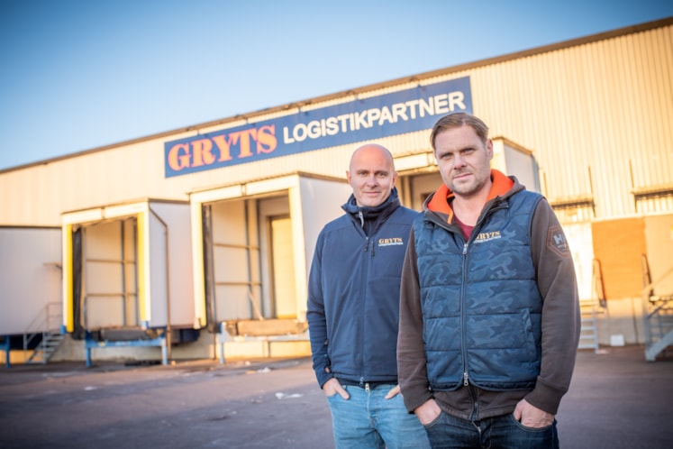 Två män som står utanför byggnaden där Gryts Logistikpartner huserar