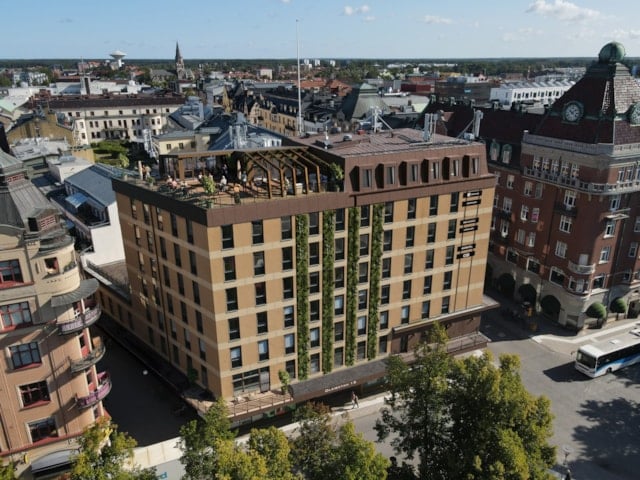 Visionsbild över den nyrenoverade fasaden med ny takterass på befintligt hus på Olaigatan 13